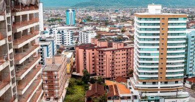 Vista aérea de área urbana brasileira afetada por inundação, com casas submersas e infraestrutura danificada, simbolizando os impactos dos eventos climáticos extremos.