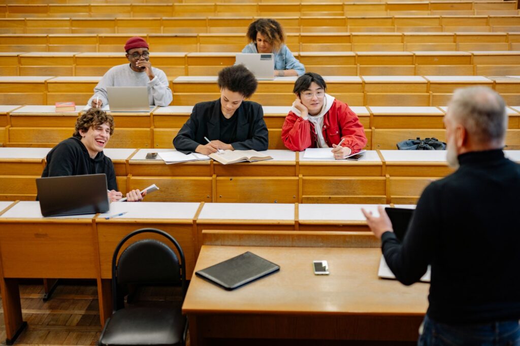 Estudantes universitários brasileiros utilizando tecnologia em sala de aula ou biblioteca, simbolizando a modernização da educação.