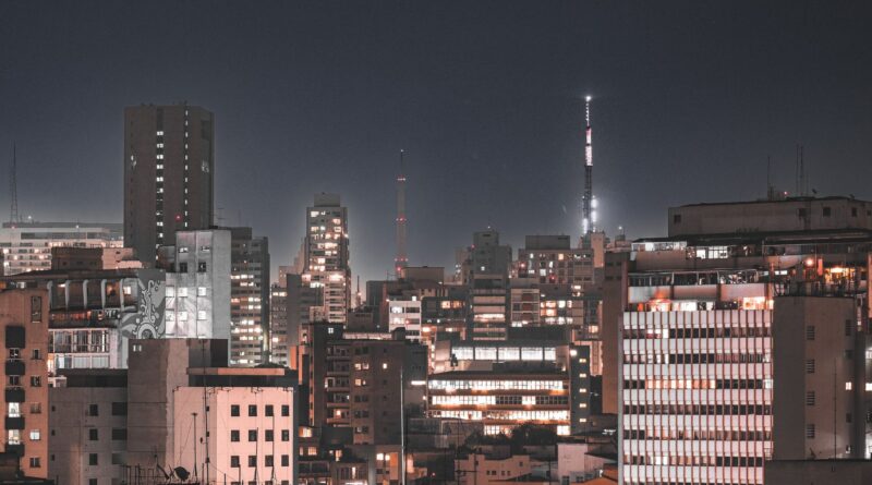 Antenas 5G em uma cidade brasileira ao pôr do sol, simbolizando a conectividade avançada.