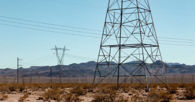 Linhas de transmissão de energia elétrica no Brasil ao pôr do sol, simbolizando a infraestrutura energética.