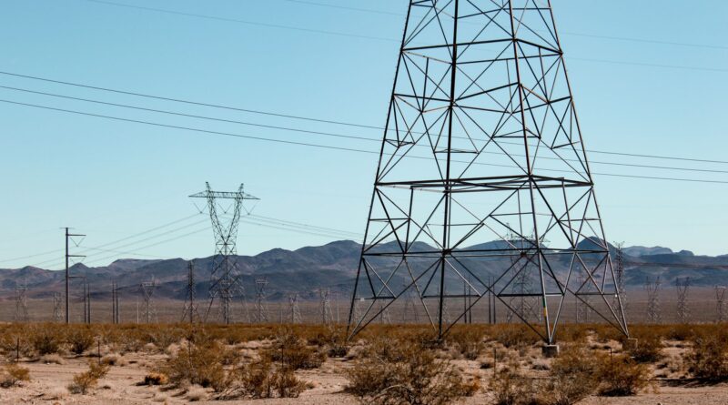 Linhas de transmissão de energia elétrica no Brasil ao pôr do sol, simbolizando a infraestrutura energética.