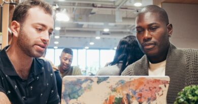 Equipe de startup brasileira trabalhando em expansão global, com mapa-múndi ao fundo