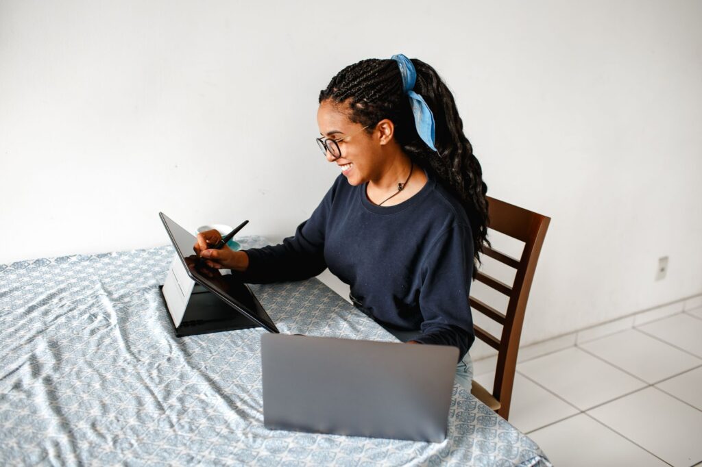 Pessoas trabalhando em computadores e tablets, com elementos visuais de criatividade digital e gráficos de crescimento.