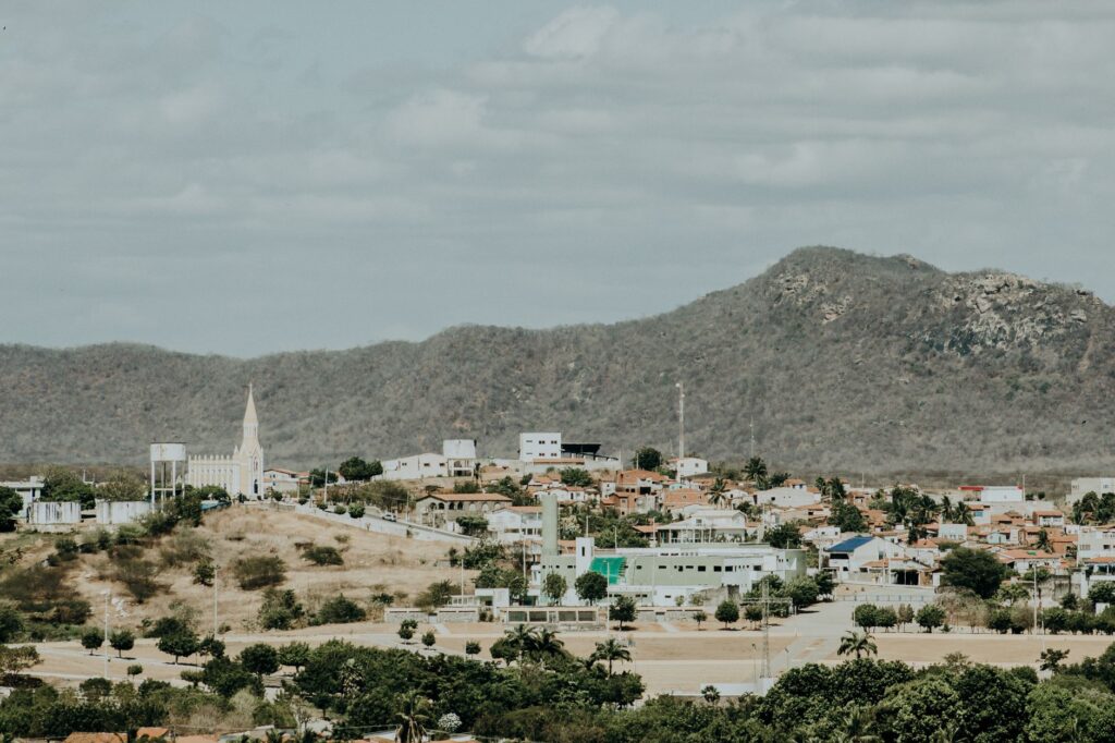 Antena de internet via satélite em uma área rural do Brasil, com paisagem verde ao fundo