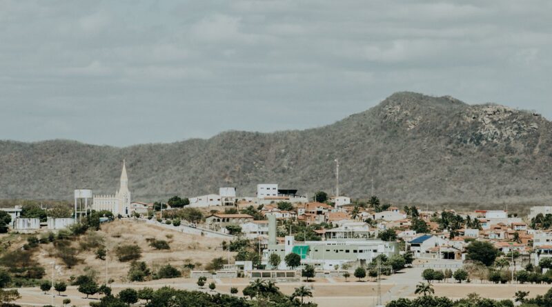 Antena de internet via satélite em uma área rural do Brasil, com paisagem verde ao fundo