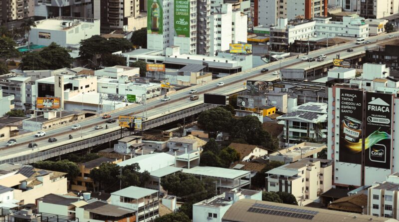 Vista aérea de uma cidade brasileira com áreas verdes e infraestrutura resistente a enchentes, simbolizando resiliência urbana.