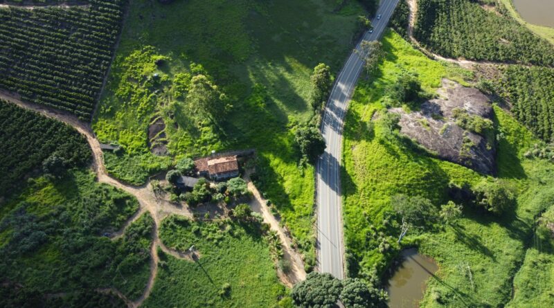 Edifícios modernos com elementos verdes e gráficos financeiros, simbolizando o financiamento sustentável no Brasil.