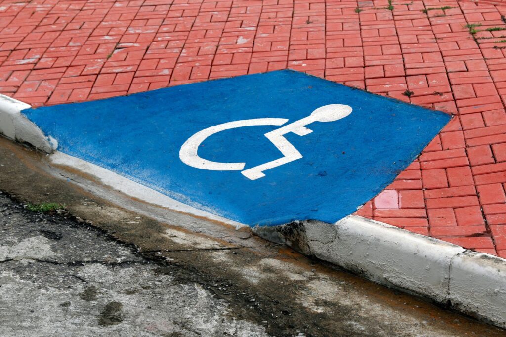 Pessoa em cadeira de rodas utilizando rampa de acesso em ambiente urbano moderno, simbolizando inclusão e acessibilidade.