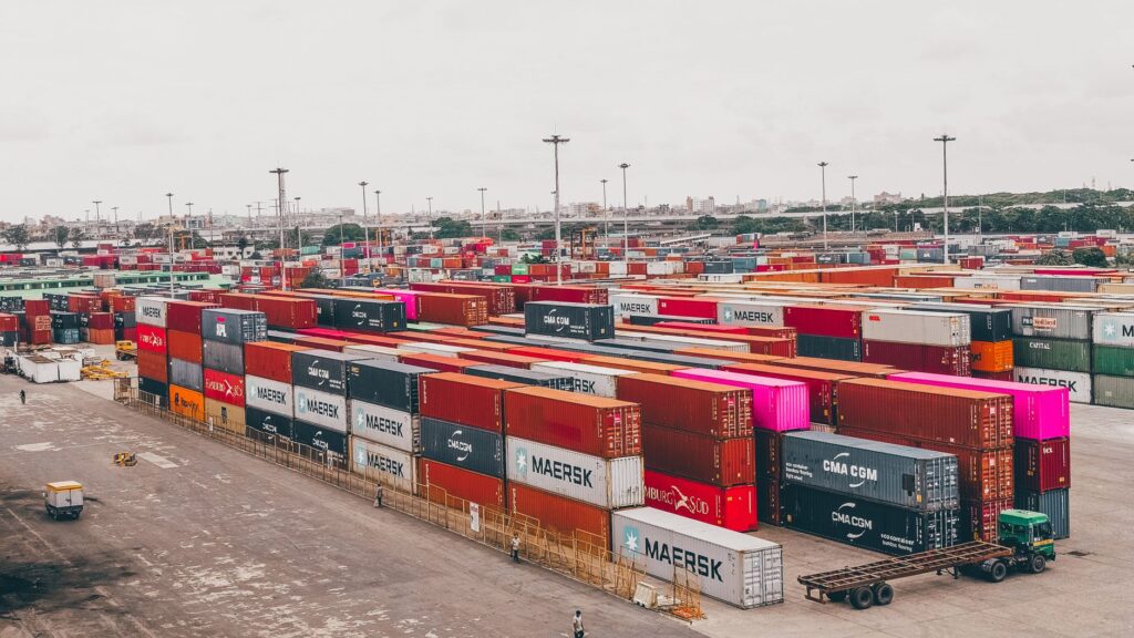 Navios de carga e contêineres em porto brasileiro, simbolizando o comércio exterior e a economia.