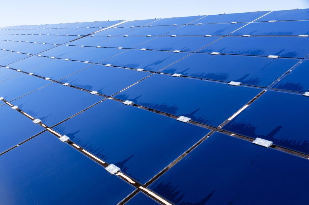 Plataforma de petróleo em alto mar com turbinas eólicas e painéis solares em primeiro plano, simbolizando a transição energética da Petrobras no Brasil.