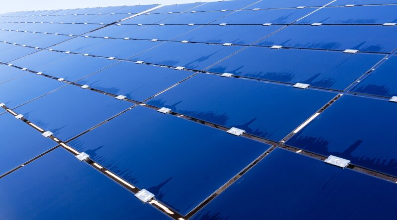 Plataforma de petróleo em alto mar com turbinas eólicas e painéis solares em primeiro plano, simbolizando a transição energética da Petrobras no Brasil.
