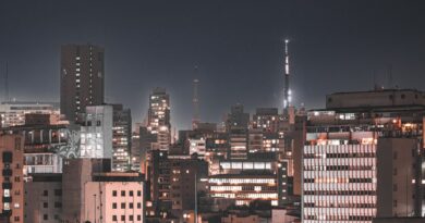 Vista aérea de uma cidade brasileira moderna com elementos tecnológicos e infraestrutura digital, simbolizando uma cidade inteligente.