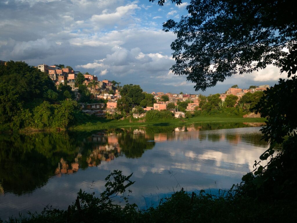 Vista aérea de uma favela no Brasil, com contraste entre a ocupação informal e a cidade formal, simbolizando o desafio da integração urbana e a necessidade de políticas públicas.