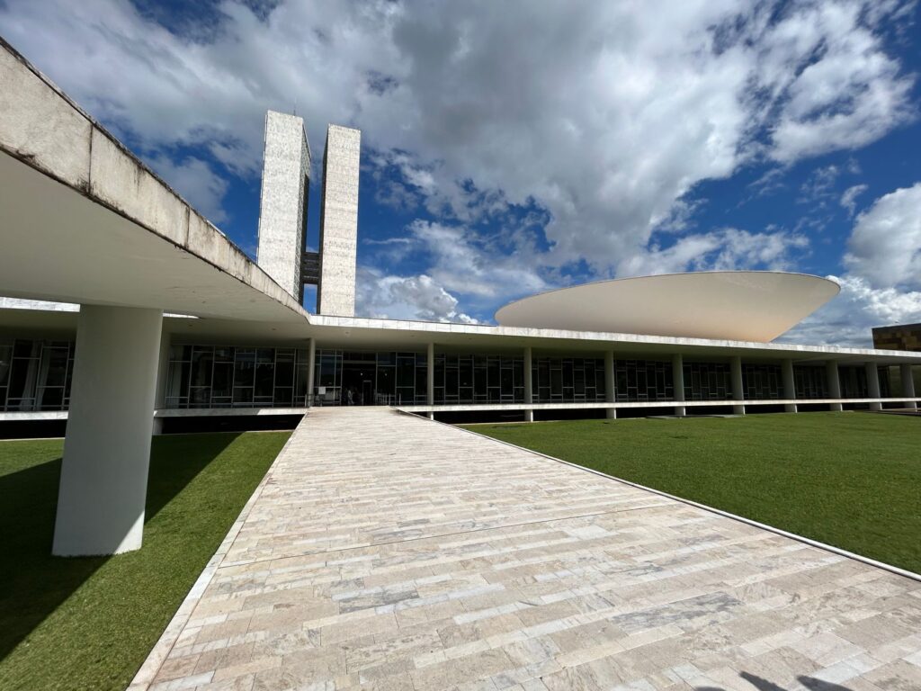 Vista aérea de Brasília, com edifícios governamentais, simbolizando a complexidade da gestão federal e a necessidade de descentralização de políticas públicas no Brasil.