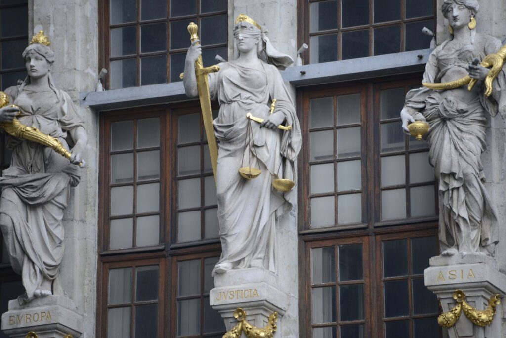 Balança da justiça em frente a um prédio do judiciário, simbolizando a Lei de Improbidade Administrativa no Brasil.