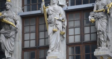 Balança da justiça em frente a um prédio do judiciário, simbolizando a Lei de Improbidade Administrativa no Brasil.