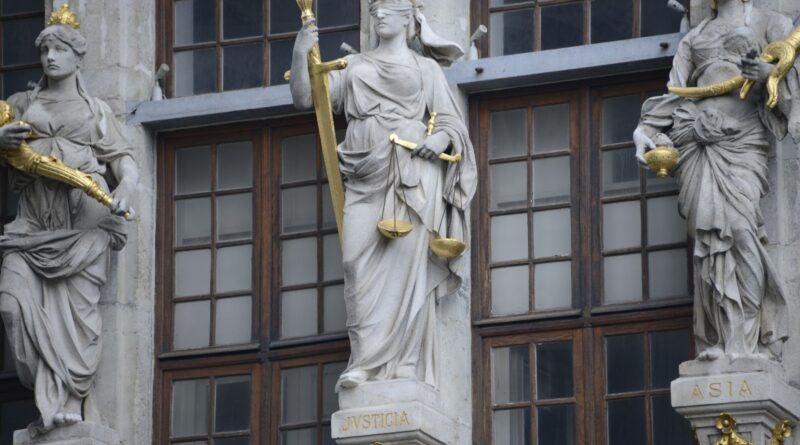 Balança da justiça em frente a um prédio do judiciário, simbolizando a Lei de Improbidade Administrativa no Brasil.