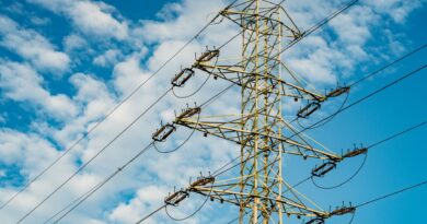 Linhas de transmissão de energia em um cenário com turbinas eólicas e painéis solares, simbolizando a modernização da rede elétrica brasileira para integrar fontes renováveis.