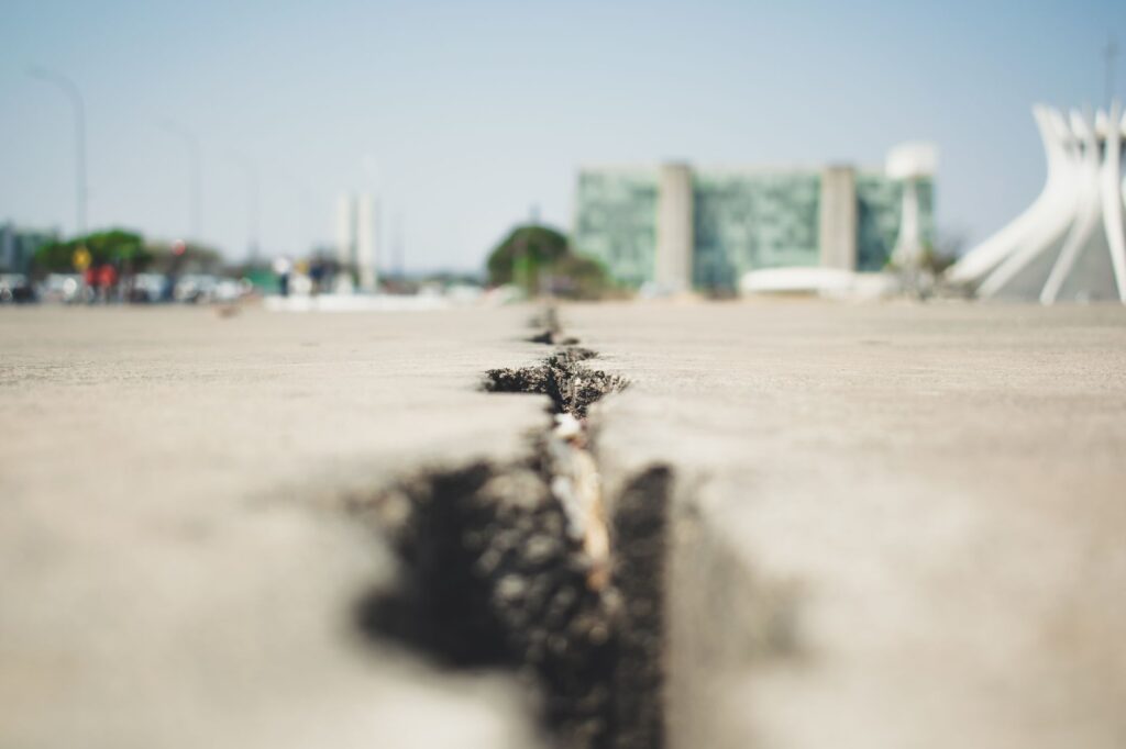 Vista aérea de uma cidade brasileira com infraestrutura adaptada para resistir a eventos climáticos extremos, como sistemas de drenagem e áreas verdes.