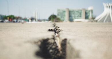 Vista aérea de uma cidade brasileira com infraestrutura adaptada para resistir a eventos climáticos extremos, como sistemas de drenagem e áreas verdes.