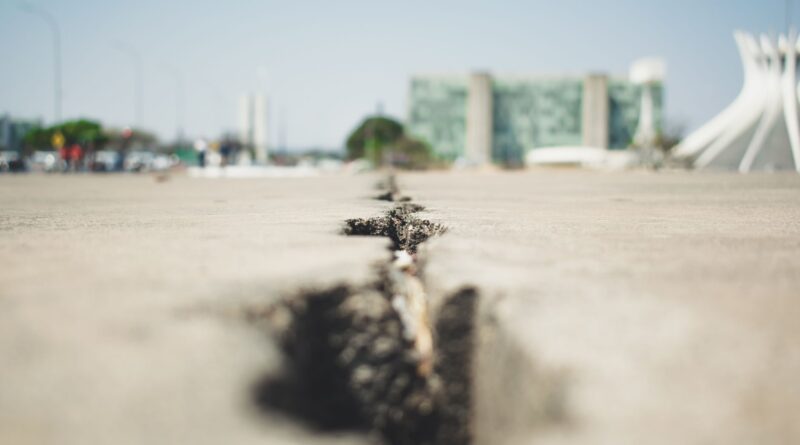 Vista aérea de uma cidade brasileira com infraestrutura adaptada para resistir a eventos climáticos extremos, como sistemas de drenagem e áreas verdes.