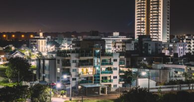 Cena urbana noturna com viatura policial e pessoas, simbolizando a violência nas cidades brasileiras.