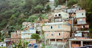 Vista aérea de uma área urbana densamente povoada no Brasil, com contraste entre edifícios formais e assentamentos informais, simbolizando o desafio do déficit habitacional.